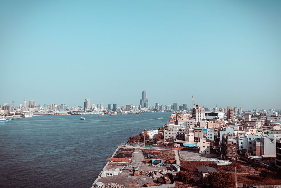 A stunning aerial view of Kaohsiung City skyline with ocean in the foreground.