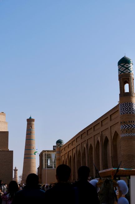 View of historic minarets in Khiva, Uzbekistan, against a clear blue sky.