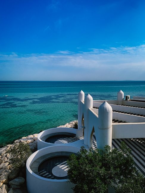 A stunning view of Al Khobar's coastal architecture against a bright blue sea and sky.