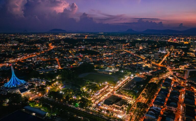 Captivating aerial shot of Kuching, Malaysia at night, showcasing vibrant city lights and iconic landmarks.