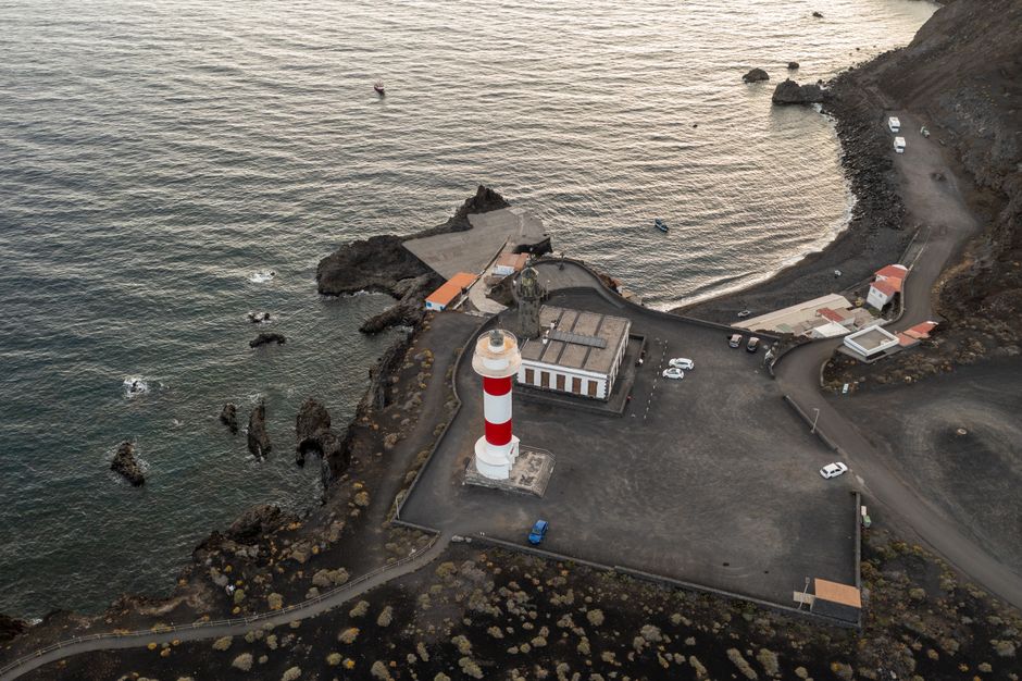 Stunning aerial shot of Fuencaliente Lighthouse on La Palma's rocky coast at dusk.