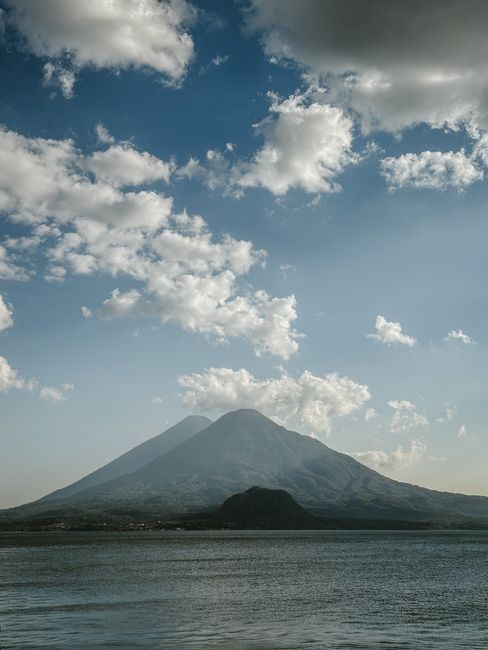 Stunning view of Volcán de Agua in Guatemala with a backdrop of clouds and clear blue sky.
