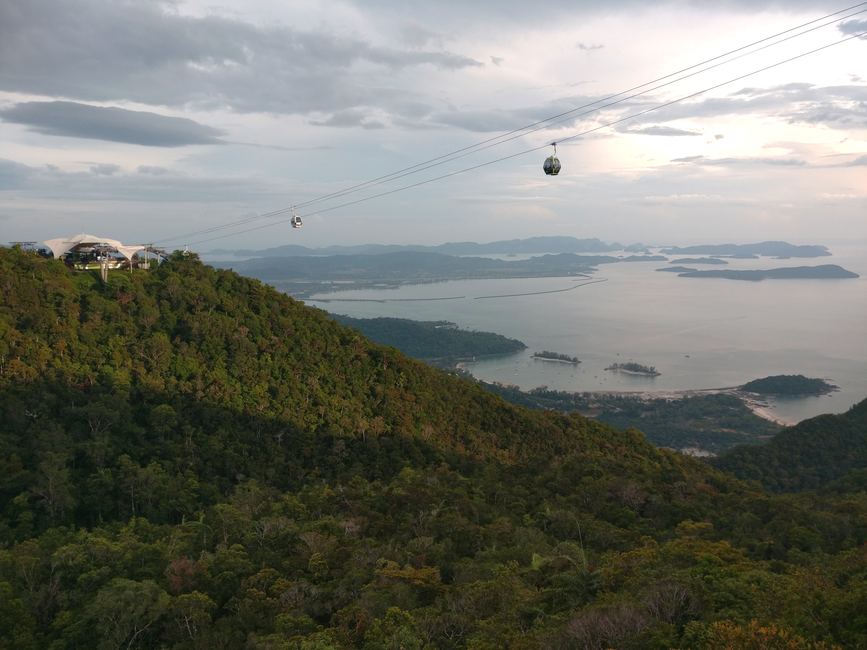 Breathtaking aerial view of Langkawi's cable car with lush forests and serene coastline.