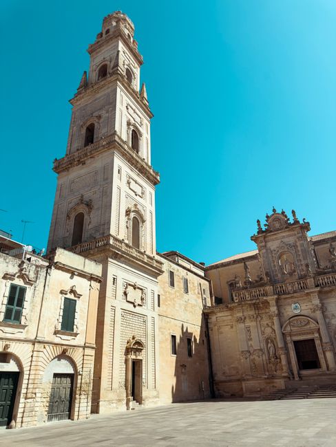 Stunning view of Lecce's historic bell tower with clear blue sky in Puglia, Italy.