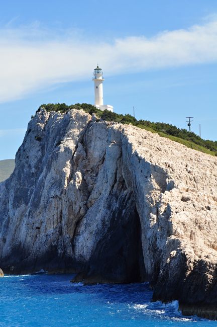A picturesque lighthouse atop the stunning cliffs of Lefkada, Greece, overlooking the azure sea.