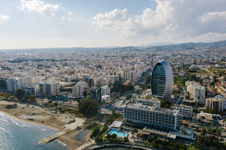 A breathtaking aerial view of Limassol's modern architecture by the seaside, featuring a unique oval-shaped building.