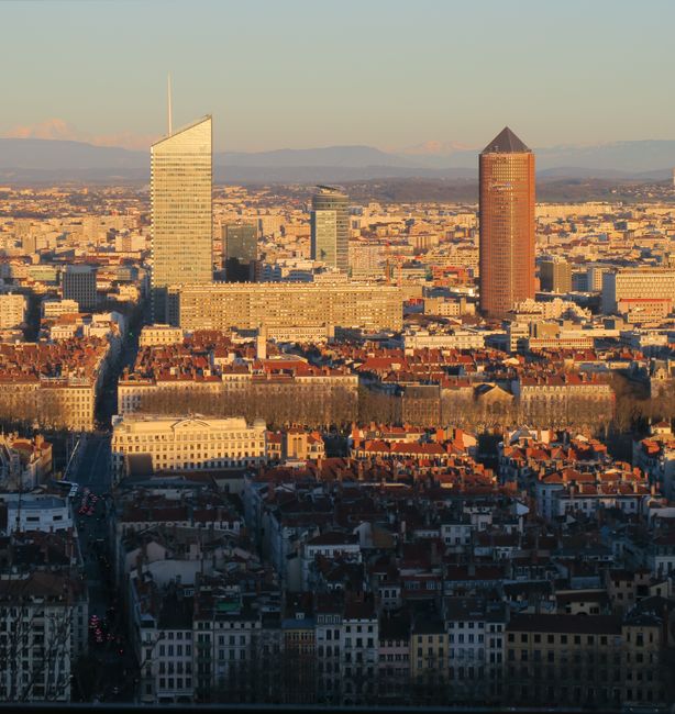 Aerial view of Lyon with modern skyscrapers and classic architecture at sunset.