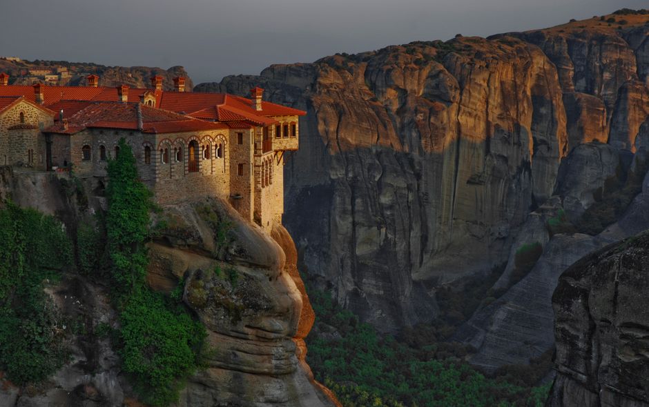 Breathtaking sunset view of Great Meteoron Monastery perched on a cliff in Meteora, Greece.