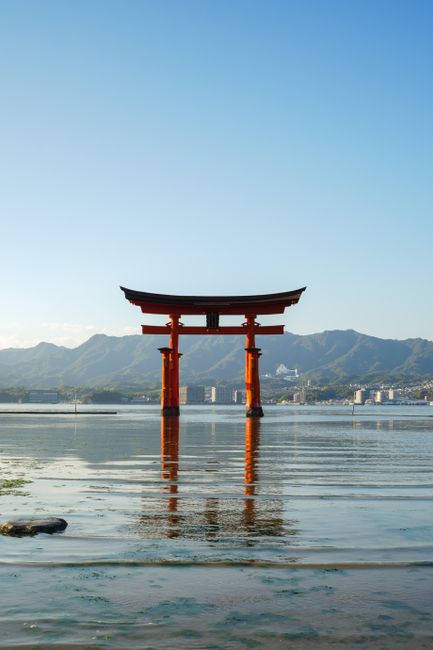 Beautiful view of the Torii Gate at Itsukushima Shrine, reflecting in tranquil waters.