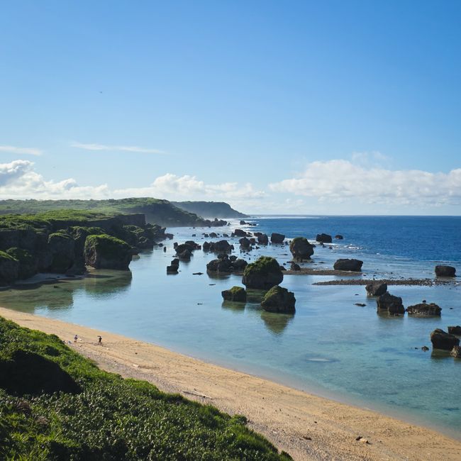 Stunning view of Miyakojima's rocky coastline and turquoise waters under a clear sky.
