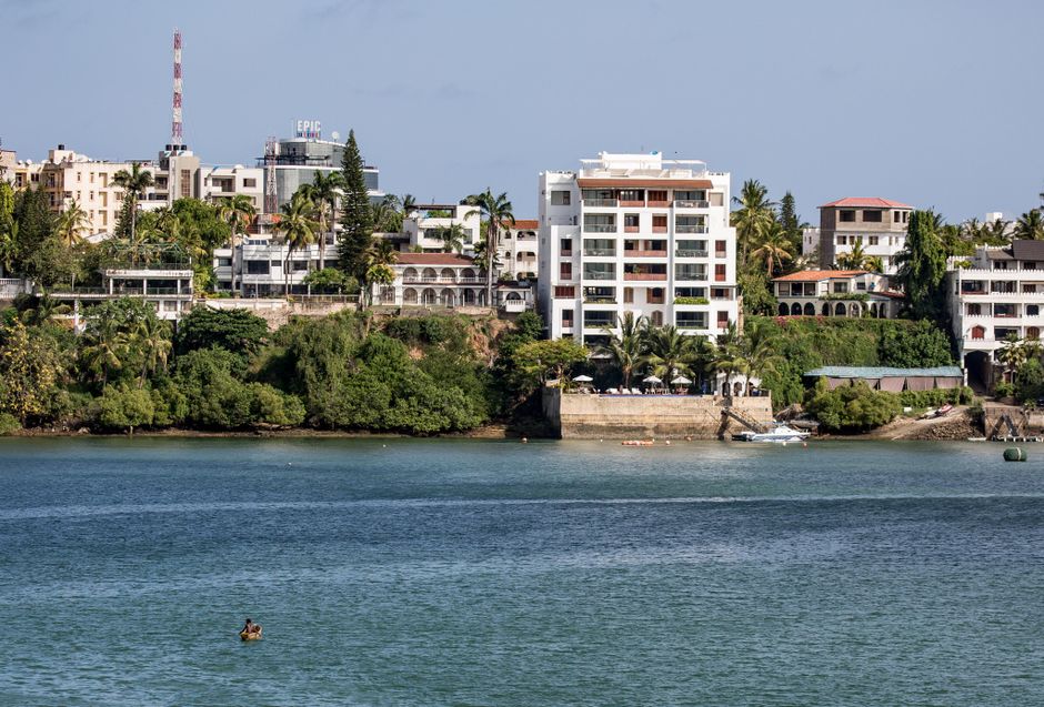 A picturesque view of Mombasa's waterfront featuring buildings and lush greenery.