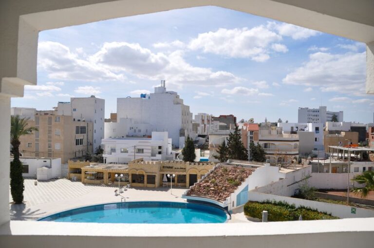 Elegant rooftop view of Tunis cityscape with blue sky and pool area.