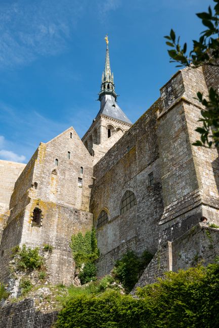 Stunning view of Mont Saint-Michel Abbey's Gothic architecture against a blue sky.