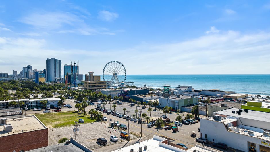 A vibrant aerial view of Myrtle Beach cityscape with Ferris wheel and ocean in the background.