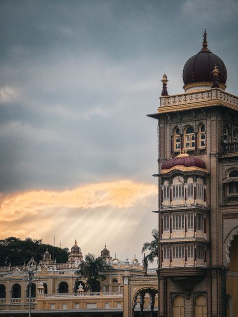 Elegant view of Mysore Palace in India during sunset with dramatic sky.