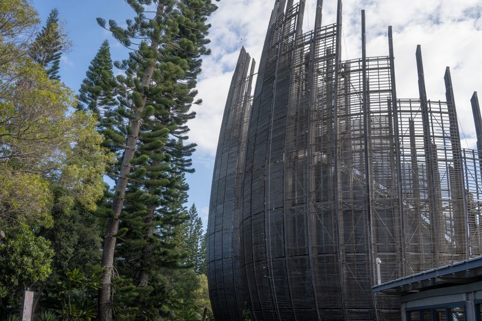 Modern architecture with distinctive lattice design surrounded by lush greenery in Kanak, New Caledonia.