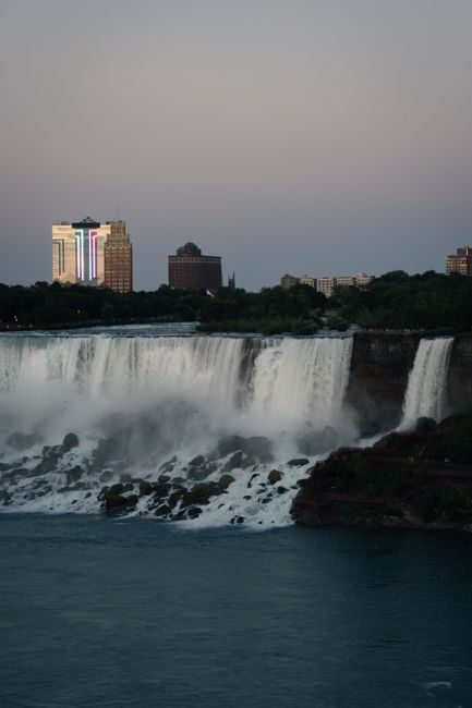 Stunning twilight view of Niagara Falls with city skyline backdrop.