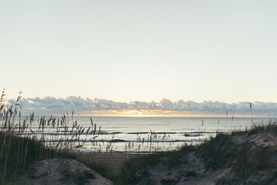 Serene sunset over sands and sea at Avon Beach, NC, tranquil and picturesque.