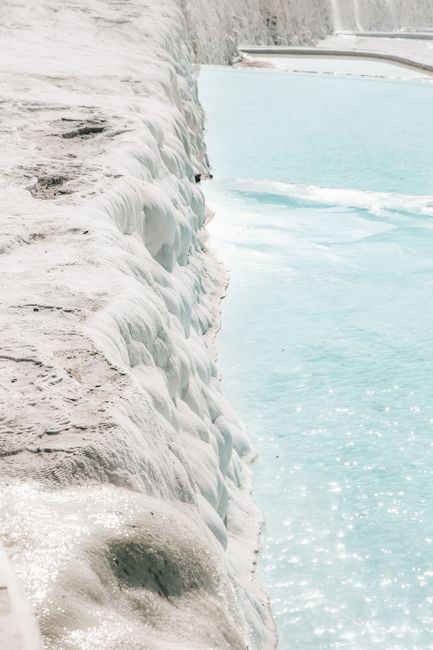 A serene view of the white limestone terraces and turquoise waters of Pamukkale, Turkey.