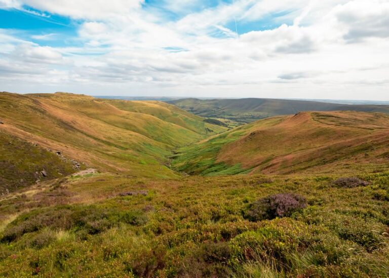 Breathtaking landscape of Kinder Scout's rolling hills under a vibrant sunset sky.