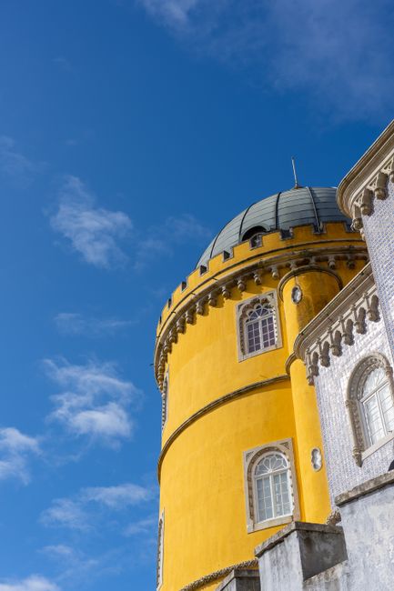 Yellow and white domed architecture of Pena Palace in Sintra, Portugal, on a sunny day.