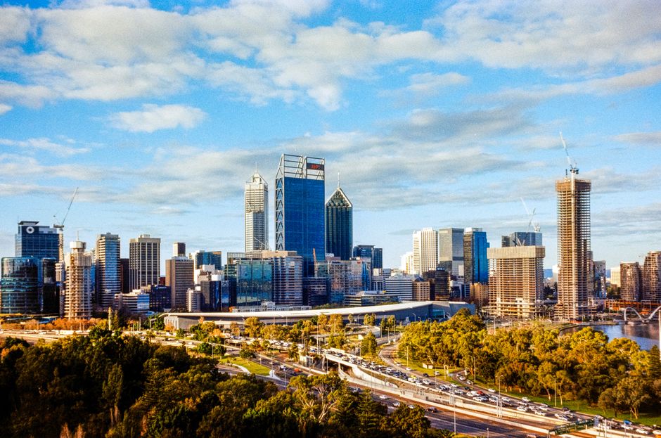 A vibrant view of Perth's CBD skyline showcasing modern skyscrapers and bustling highways.
