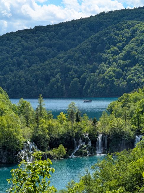 A tranquil landscape with waterfalls at Plitvice Lakes National Park, Croatia, surrounded by lush greenery.