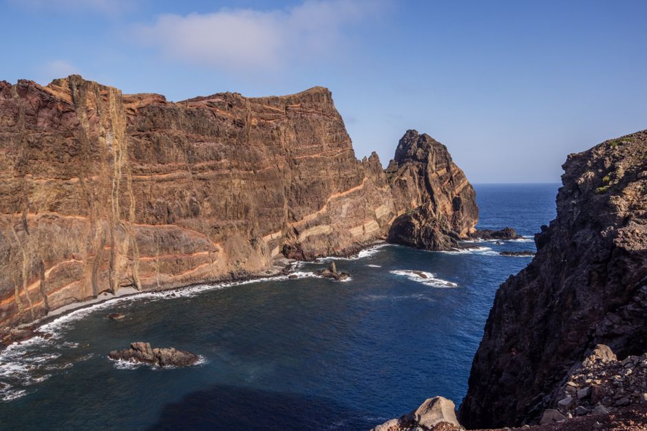 Majestic coastal cliffs overlooking a deep blue ocean, captured in vibrant sunlight.