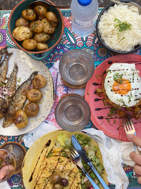Top view of traditional Portuguese meal with fish, potatoes, rice, and egg in Lisbon, Portugal.