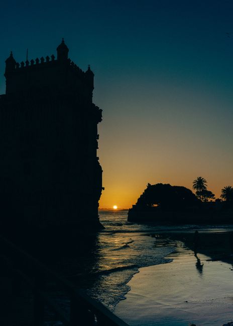 Captivating sunset silhouette of Belém Tower by the river in Lisbon, Portugal.