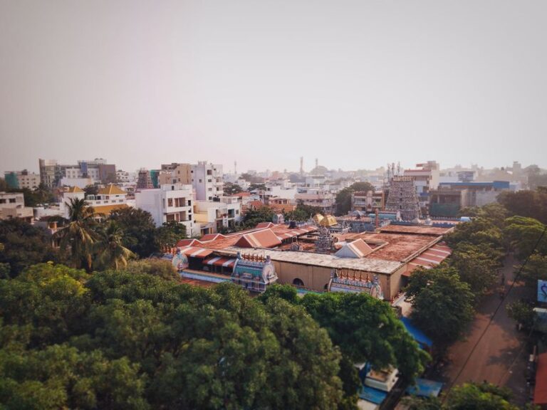 Scenic aerial view of a temple in Puducherry, India with surrounding urban cityscape and lush greenery.