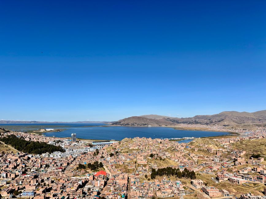 Aerial view of Puno city with Lake Titicaca in the background, showcasing stunning Peruvian landscapes.