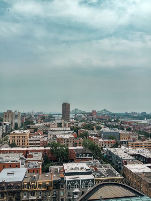 Stunning aerial view of Montréal's urban landscape featuring a prominent bridge under a cloudy sky.