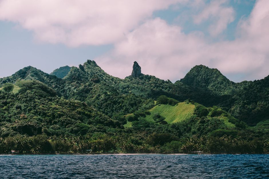 Scenic view of lush mountain range and ocean, perfect for travel and nature themes.
