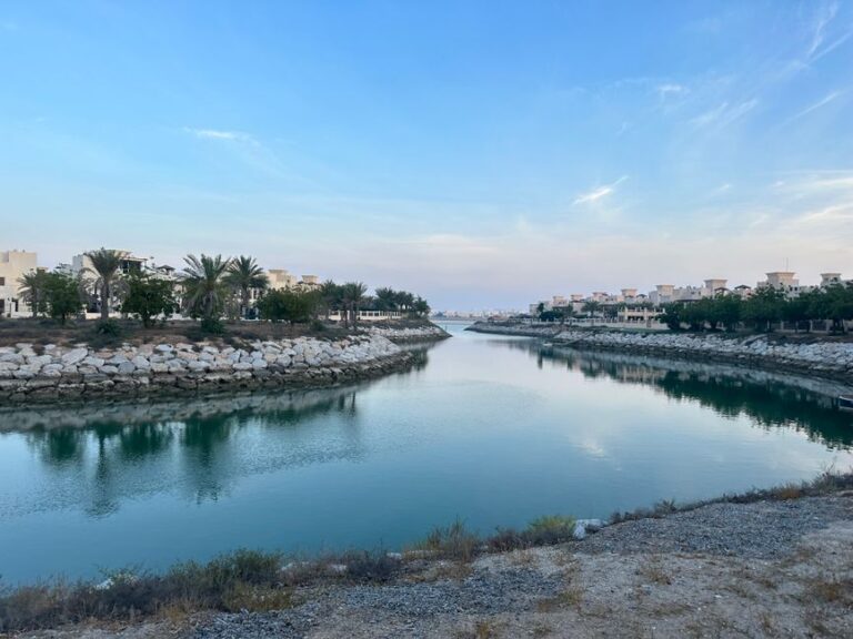 Beautiful canal amid residential area with palm trees in Ras Al-Khaimah, United Arab Emirates.