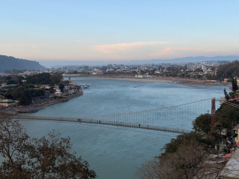 A breathtaking view of the iconic Laxman Jhula bridge in Rishikesh over the Ganges River during daytime.