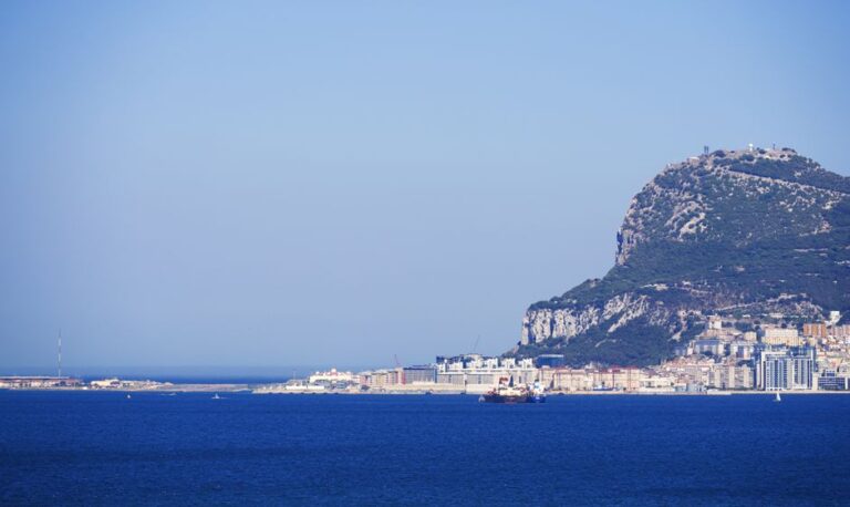 Scenic view of the iconic Rock of Gibraltar, with clear blue sky and sea, ideal for travel imagery.