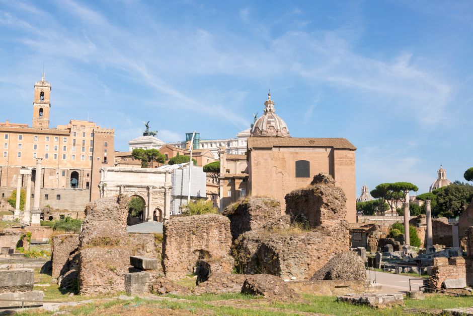 Explore the historic ruins of Rome under a clear blue sky.
