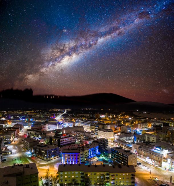 Beautiful view of Rovaniemi city under a stunning starry night sky with the Milky Way visible.