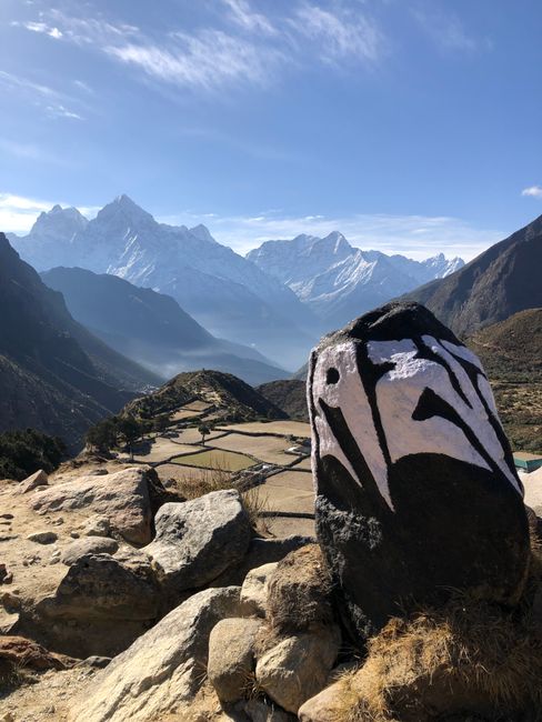 Beautiful view of Himalayan mountains with a uniquely decorated rock in foreground, Nepal.