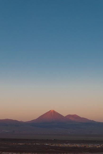 A stunning view of a volcano under a vibrant sunset sky in the Atacama Desert, Chile.