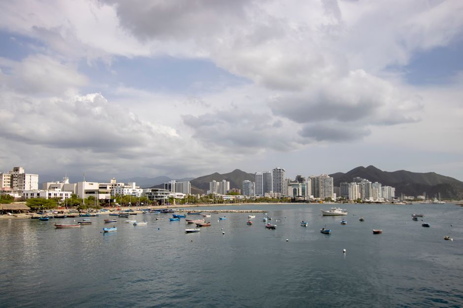 Skyline of Santa Marta, Colombia, with boats in the foreground and mountains in the background.