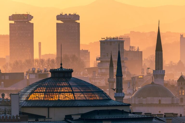 Golden hour view of Sarajevo skyline with notable landmarks in evening light.