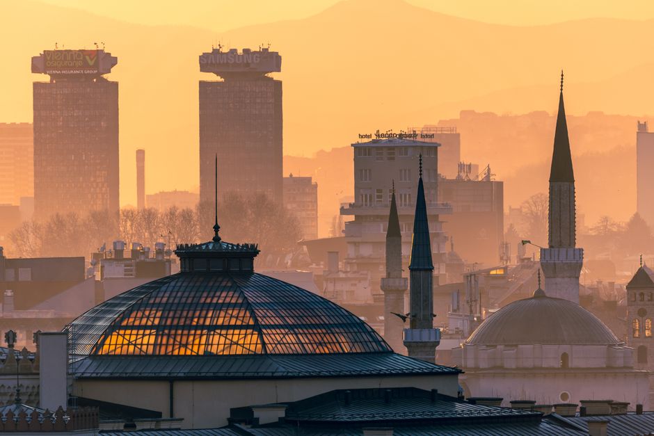 Golden hour view of Sarajevo skyline with notable landmarks in evening light.