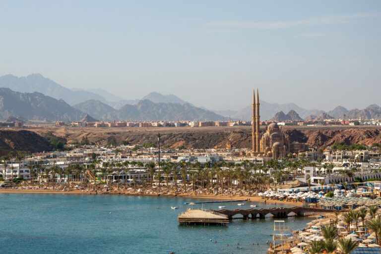 A stunning aerial view of Sharm El Sheikh featuring the coastline and city landmarks against a mountainous backdrop.
