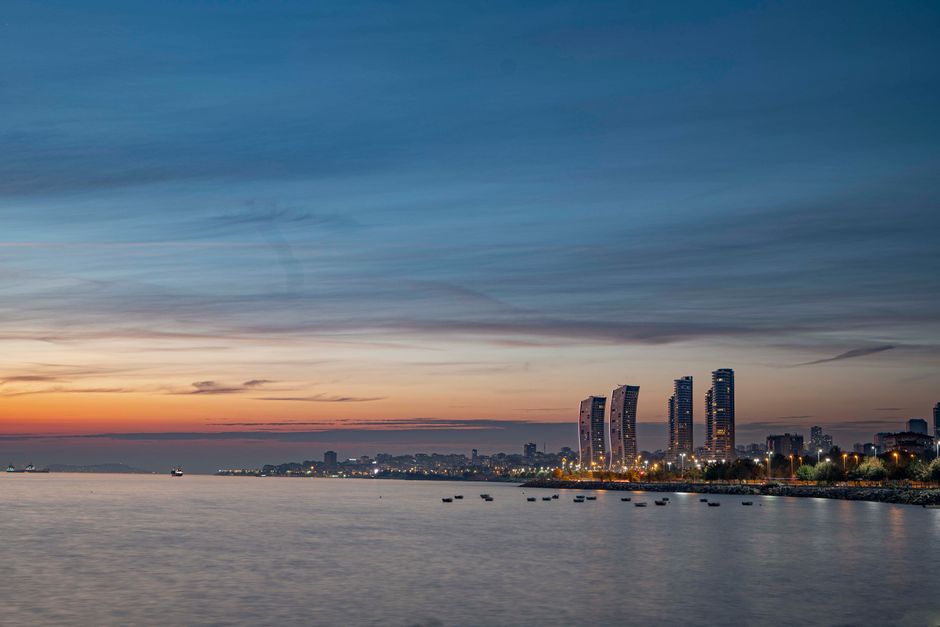 Stunning twilight view of Istanbul's skyline and seashore, highlighting modern skyscrapers and colorful sky.