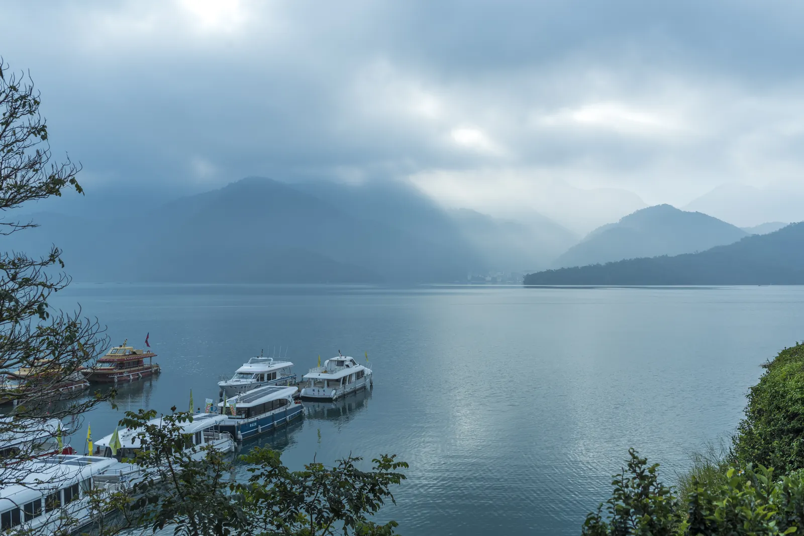 Tourist boats at Shuishe Pier on a misty morning at Sun Moon Lake, Nantou, Taiwan