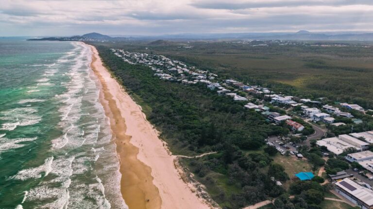 Stunning aerial view of the Sunshine Coast beach in Queensland, Australia, showcasing waves and coastal greenery.