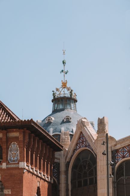 Explore the intricate architecture of Valencia's Central Market dome against a clear sky.