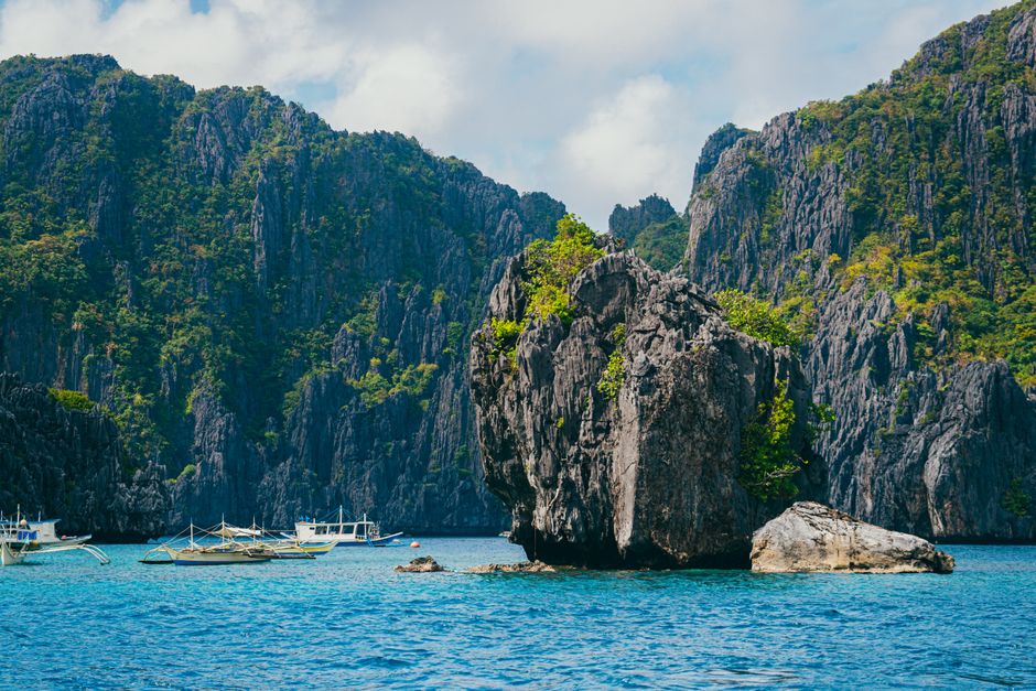Breathtaking view of tropical rock formations and boats in El Nido, Palawan.